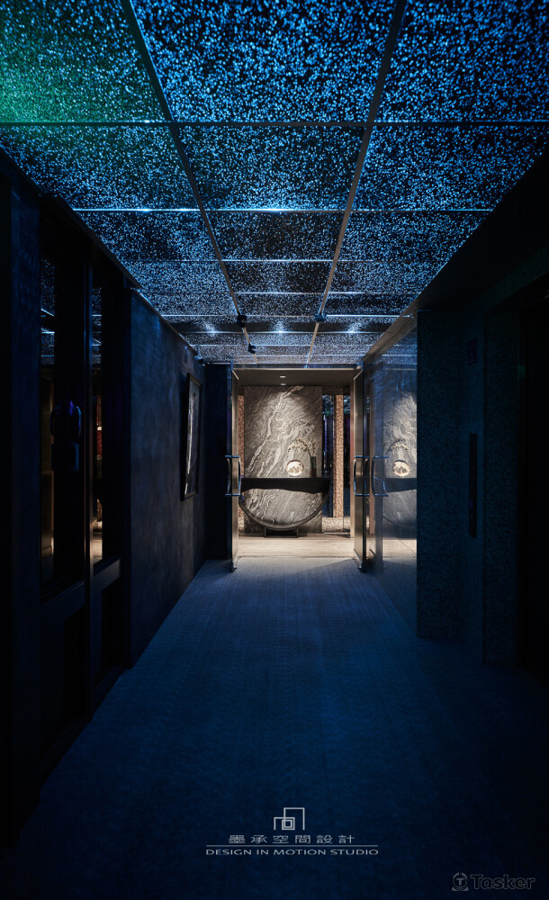 如幻。 藍色星空廊道遠端，黃光聚焦在銀灰仿古的光束銀河石材，這是個截然不同的世界